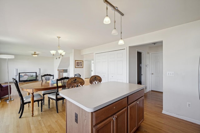 61 Old Carriage Ln, Lapeer, MI 48446 - kitchen with hanging light fixtures, light countertops, a notable chandelier, light wood-style floors, and open floor plan