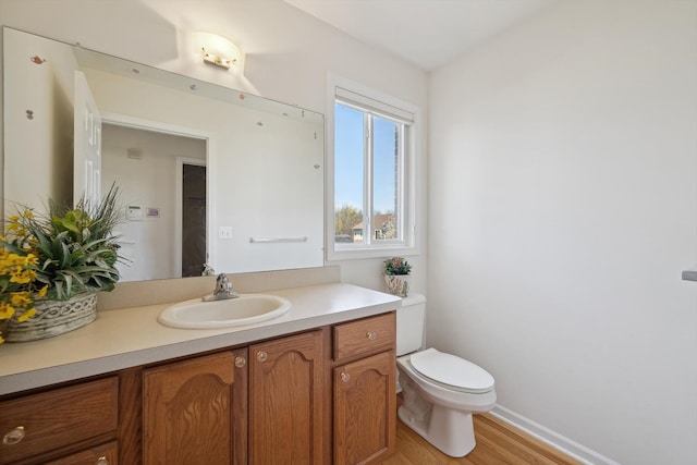 61 Old Carriage Ln, Lapeer, MI 48446 - bathroom featuring toilet, baseboards, wood finished floors, and vanity