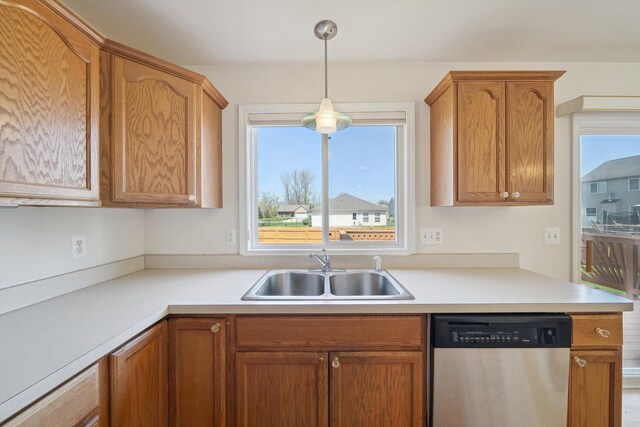 61 Old Carriage Ln, Lapeer, MI 48446 - kitchen featuring stainless steel dishwasher, brown cabinetry, light countertops, a sink, and decorative light fixtures