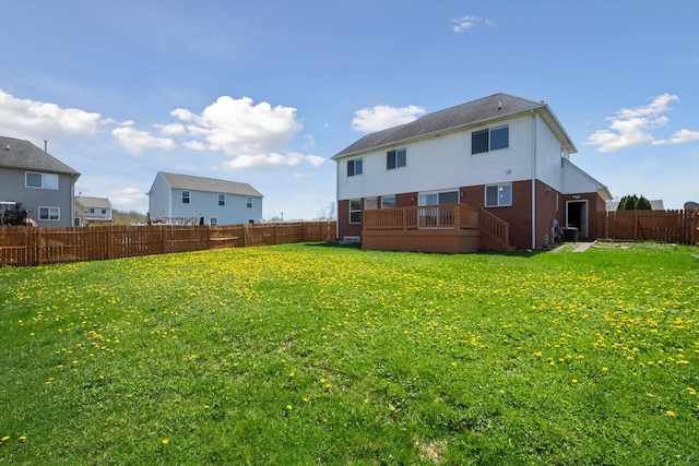 61 Old Carriage Ln, Lapeer, MI 48446 - back of house featuring a lawn, brick siding, a wooden deck, and a fenced backyard