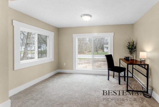 carpeted office space featuring baseboards and visible vents