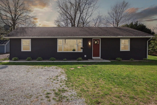 single story home featuring a shingled roof and a front lawn