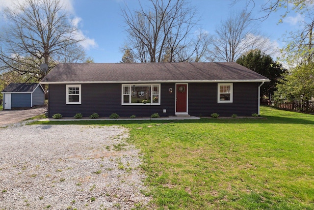 single story home with an outdoor structure, fence, a storage shed, and a front yard