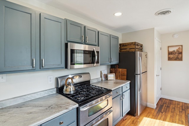 kitchen featuring appliances with stainless steel finishes, light countertops, recessed lighting, light wood-type flooring, and visible vents