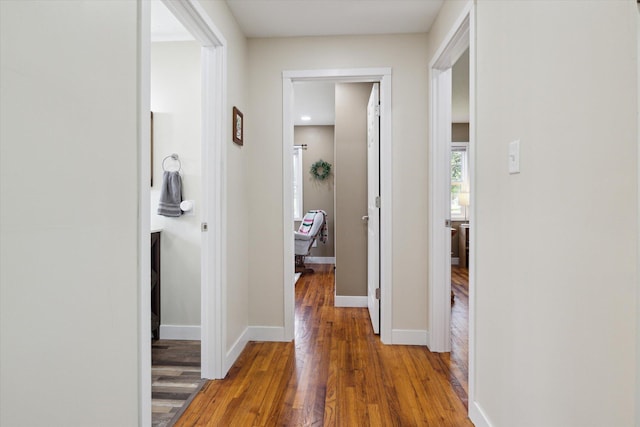 hallway with baseboards and wood finished floors