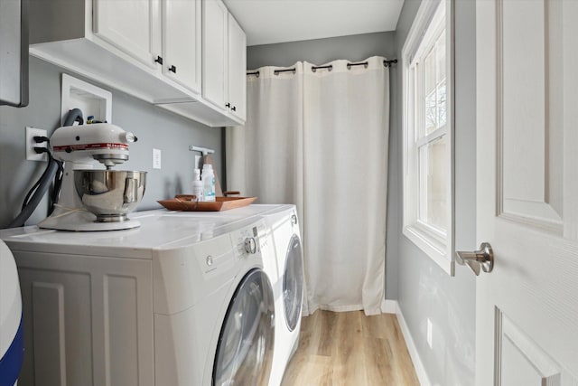 laundry room with light wood-style floors, cabinet space, baseboards, and washing machine and clothes dryer