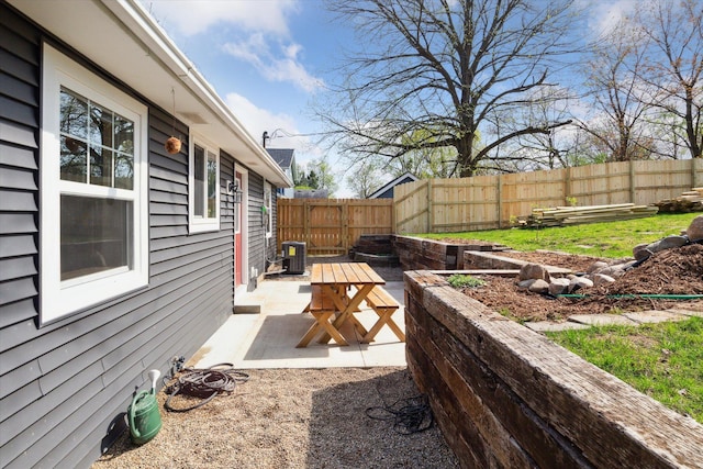 view of yard featuring a patio, a fenced backyard, and central AC