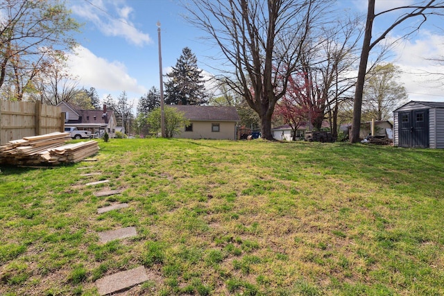 view of yard featuring fence, an outbuilding, and a storage shed