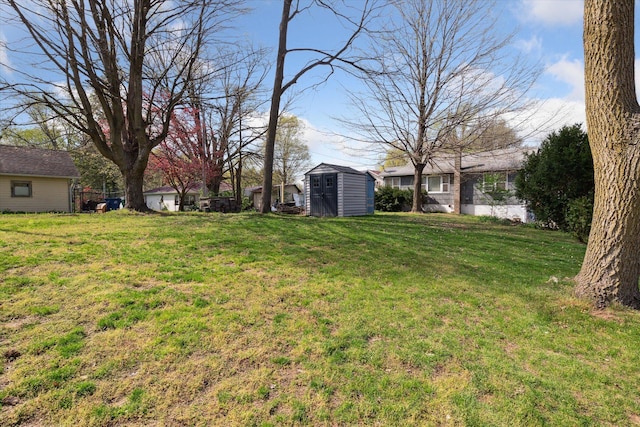 view of yard with an outbuilding, fence, and a storage shed