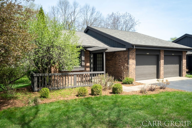 ranch-style home with a shingled roof, brick siding, a garage, a front yard, and driveway