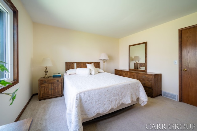bedroom featuring light colored carpet and visible vents
