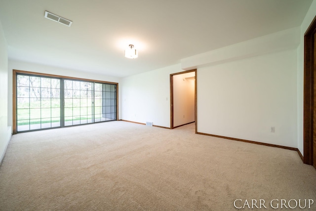 spare room with visible vents, baseboards, and light colored carpet