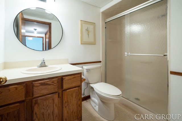 full bathroom featuring toilet, a shower stall, tile patterned flooring, and vanity