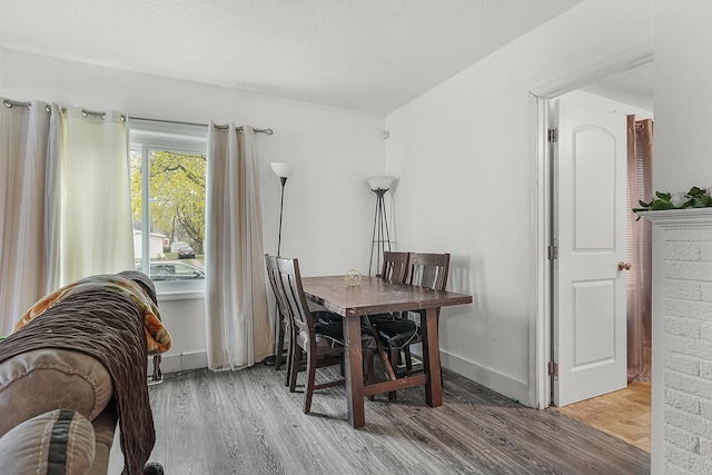 dining space featuring baseboards and wood finished floors