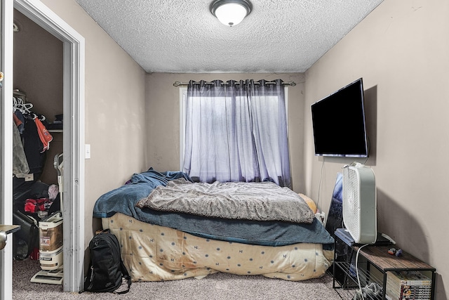 bedroom featuring a textured ceiling and carpet