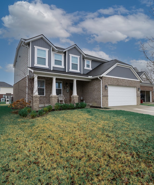 craftsman-style home with board and batten siding, covered porch, a front yard, brick siding, and an attached garage