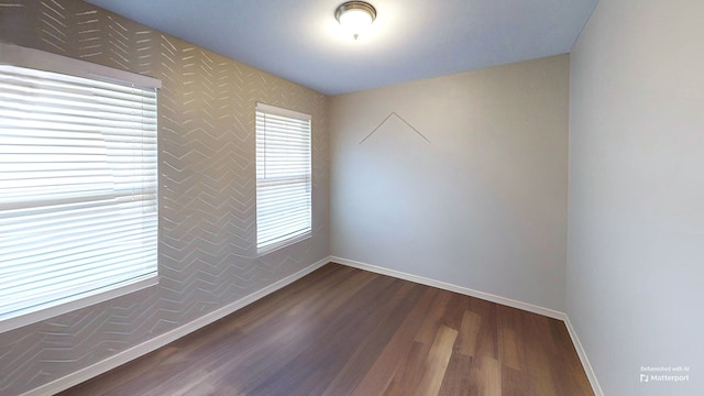 empty room with baseboards and dark wood-style floors