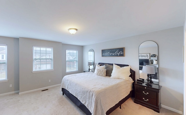 bedroom with visible vents, baseboards, and light colored carpet
