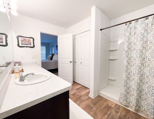 full bath featuring vanity, ensuite bathroom, a stall shower, and wood finished floors