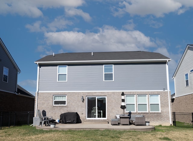 rear view of house featuring brick siding, a fenced backyard, a patio area, and a yard