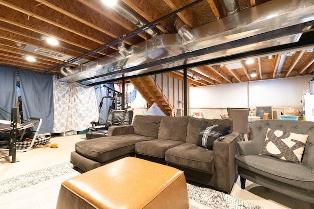 living room with concrete flooring, visible vents, and stairway