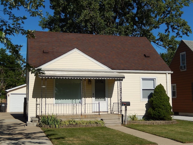view of front of house featuring a garage, a porch, and a front lawn