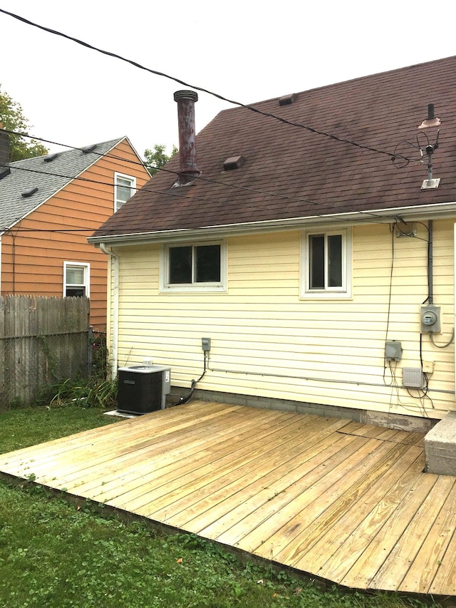 rear view of house featuring fence, a chimney, cooling unit, and a deck