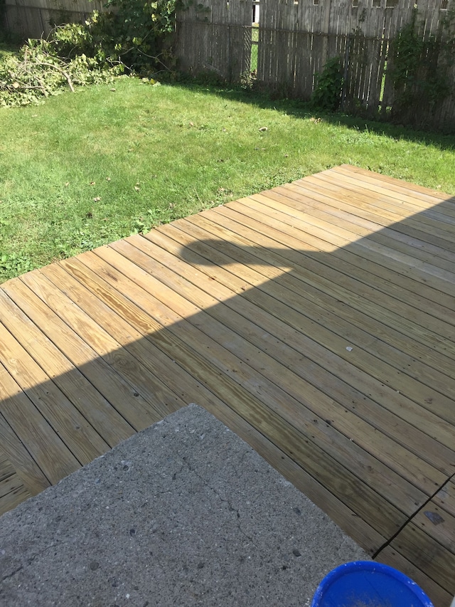 wooden deck featuring a lawn and fence