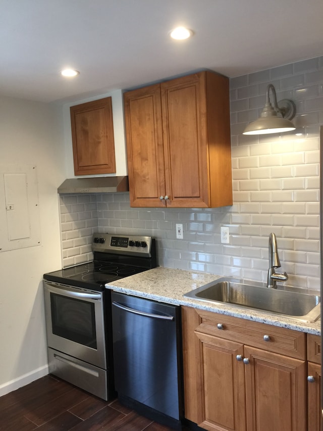 kitchen featuring decorative backsplash, brown cabinetry, a sink, dark wood-style floors, and stainless steel appliances