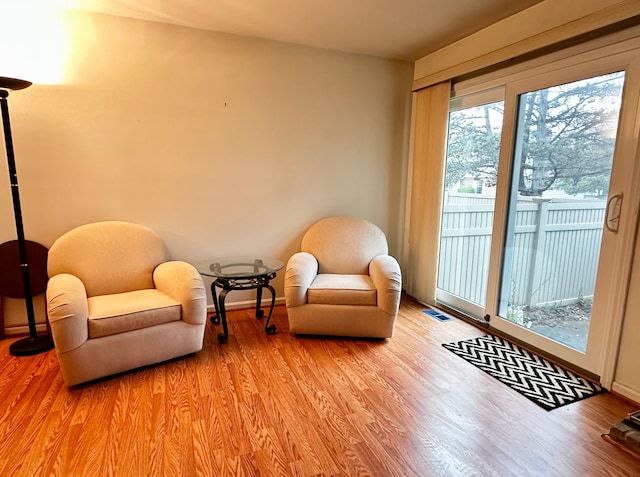 sitting room with baseboards and light wood-style flooring