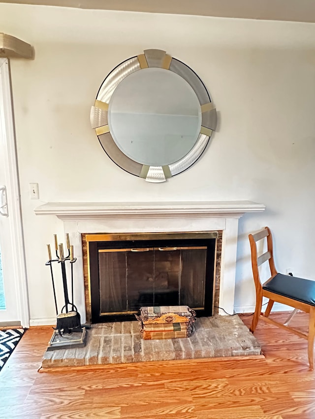 details with a glass covered fireplace, baseboards, and wood finished floors