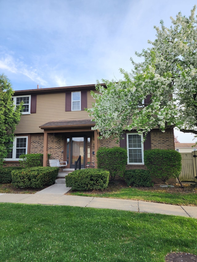 view of front of home with a front yard and brick siding