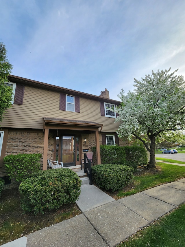 multi unit property with a chimney and brick siding