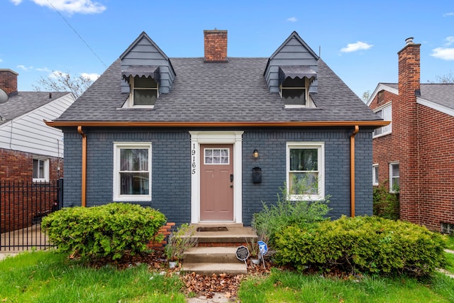 19165 Rutherford St, Detroit, MI 48235 - cape cod home featuring a chimney, roof with shingles, brick siding, and fence