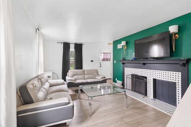 19165 Rutherford St, Detroit, MI 48235 - living room featuring a tiled fireplace, visible vents, and wood finished floors