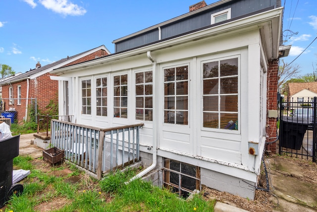 19165 Rutherford St, Detroit, MI 48235 - rear view of property featuring a sunroom, fence, a wooden deck, and a chimney