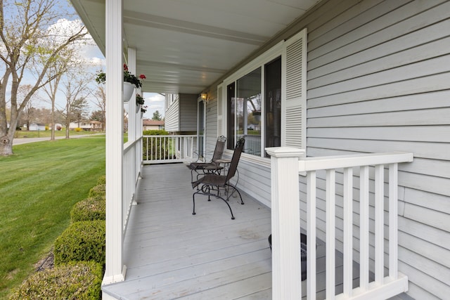 deck featuring a porch and a yard