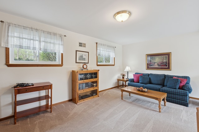 carpeted living area featuring baseboards and visible vents