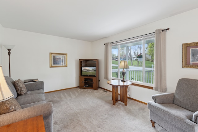 living area featuring baseboards, light carpet, and visible vents