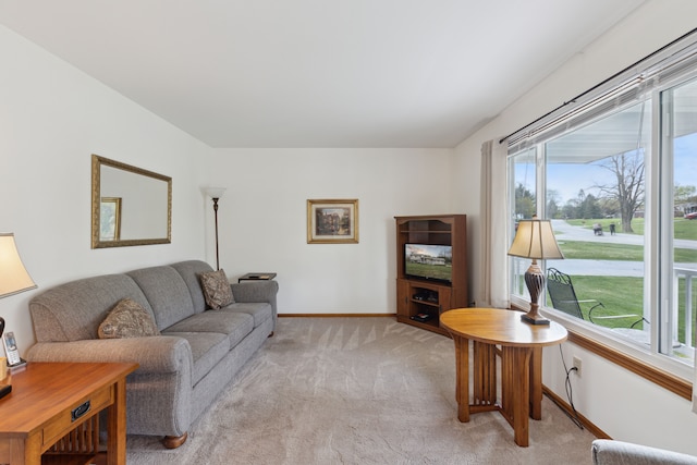 living room featuring baseboards and light colored carpet