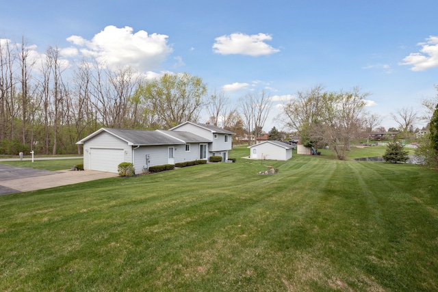 view of yard with concrete driveway and a garage