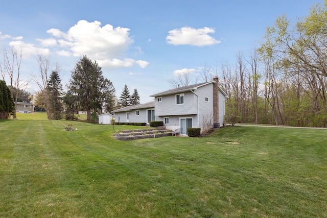 rear view of house with a lawn and a chimney