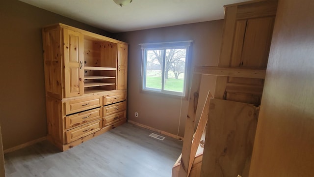 interior space with baseboards, visible vents, and light wood-style floors