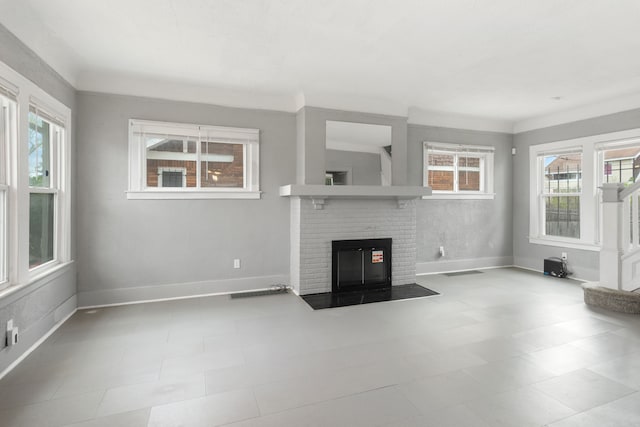 unfurnished living room featuring a brick fireplace, baseboards, and visible vents