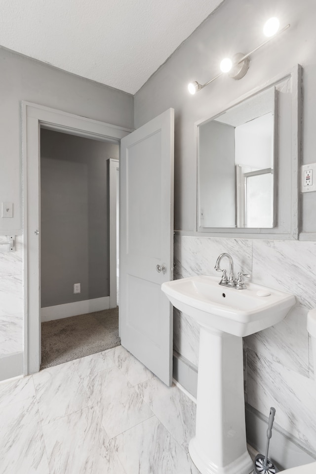 bathroom featuring marble finish floor and a sink