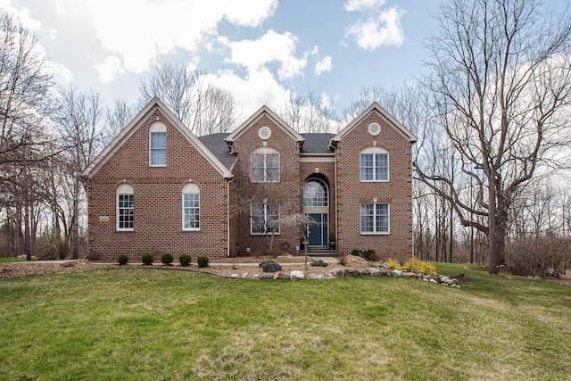 traditional-style house with brick siding and a front lawn