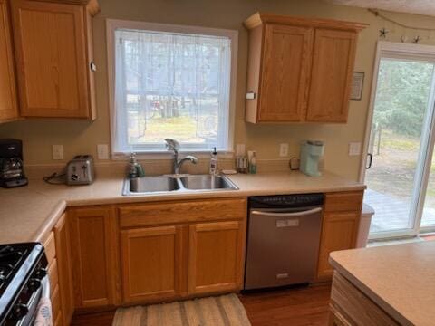 kitchen with light countertops, a sink, light wood-type flooring, and stainless steel appliances