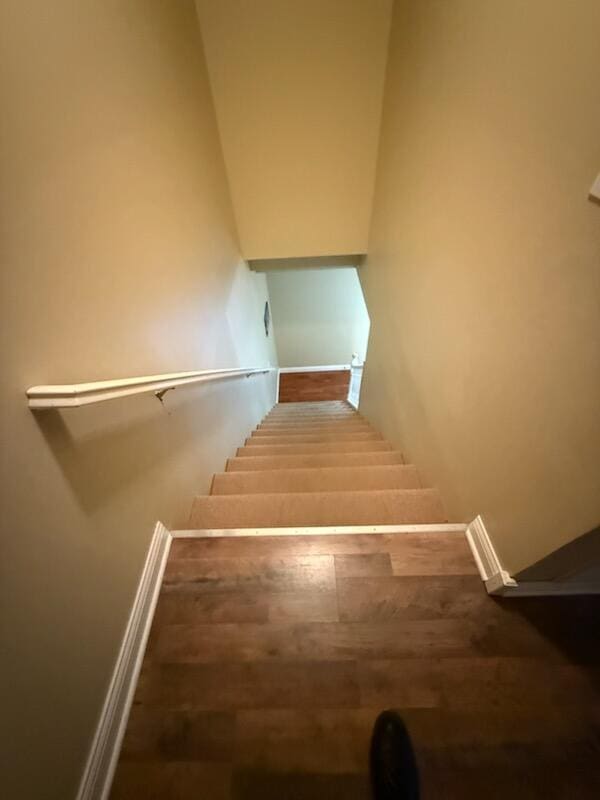 stairs with baseboards and wood finished floors