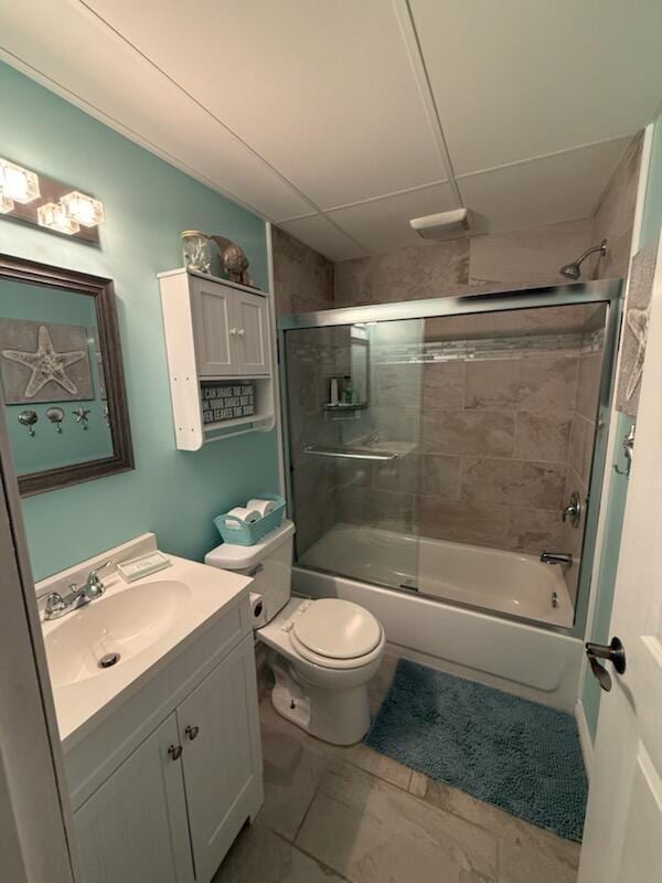full bath featuring toilet, bath / shower combo with glass door, and vanity