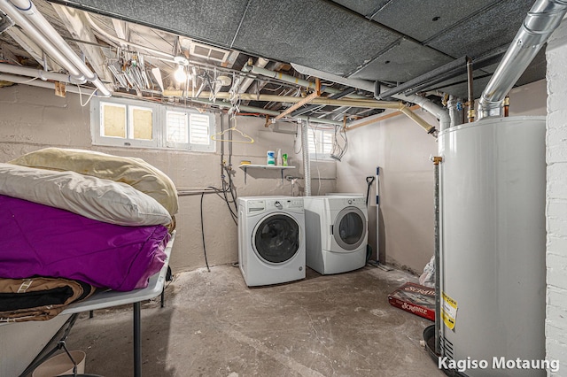 clothes washing area featuring water heater, laundry area, washing machine and dryer, and a healthy amount of sunlight